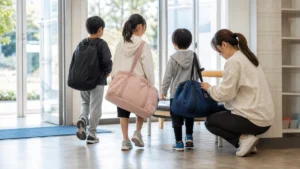 同じ習い事の会場へ向かう3人きょうだいと持ち物を確認する保護者